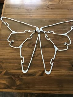 a wooden table topped with a metal butterfly cut out of it's back legs