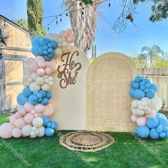 an arch with balloons and the word do she? on it in front of a headstone