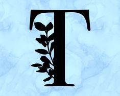 the letter t is made up of leaves and branches on a blue marble slabboard background