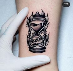 a black and white tattoo on the arm of a person with an hourglass in it