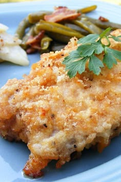 a blue plate topped with chicken and green beans