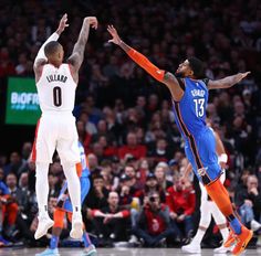 two basketball players in the middle of a game, one is jumping up to block the ball