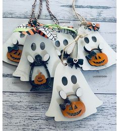 three halloween decorations hanging from strings on a white wooden table with text overlay that says,