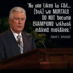 a man in a suit and tie standing at a podium with a quote on it