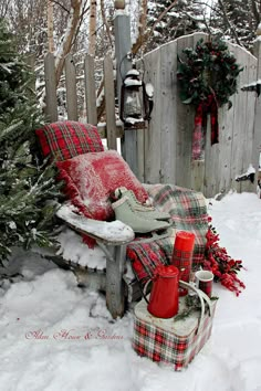 a bench covered in snow next to a christmas tree and other items on the ground