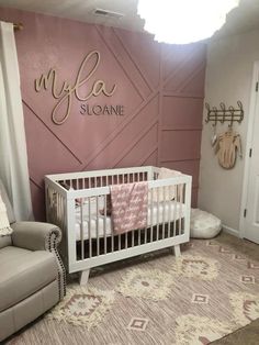 a baby's room with a pink wall and white crib in the corner