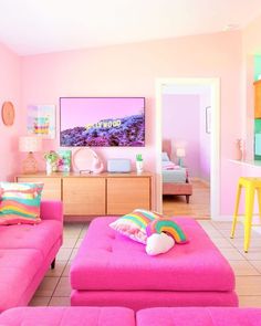 a living room filled with pink couches and colorful pillows