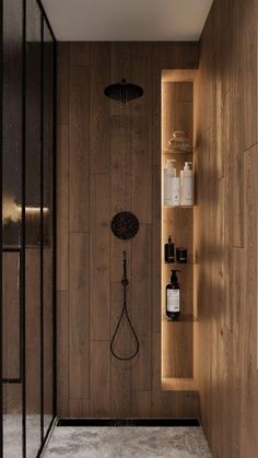 a bathroom with wooden walls and shelving on the wall next to it is a shower head