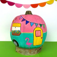 a painted pumpkin sitting on top of a green table