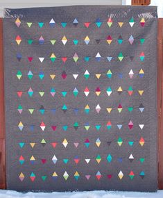 a quilt with many different colored triangles on it