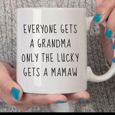 a woman holding a coffee mug that says everyone gets a grandma only the lucky gets a mamma