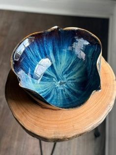 a blue and white bowl sitting on top of a wooden table next to a wall