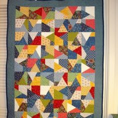 a colorful quilt hanging on the wall