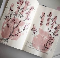 an open book with pink hand prints on it