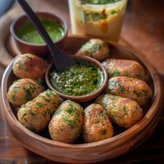 a wooden bowl filled with food next to dipping sauce