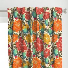 an orange and green flowered curtain hanging on a window sill in front of a white wall