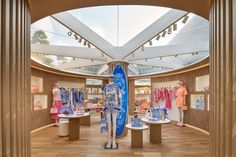 the inside of a clothing store with mannequins and surfboards on display