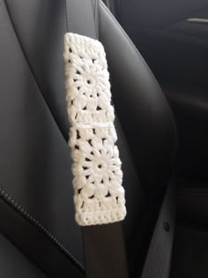 a crocheted seat belt in the back of a car