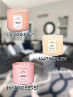 three different types of candles on display in front of a room with couches and tables