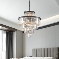 a bedroom with a large bed and a chandelier hanging from it's ceiling