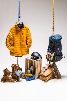 an assortment of items are hanging from hooks and on the clothes line, including a yellow puffy jacket