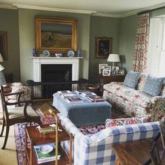 a living room filled with furniture and a fire place under a painting on the wall