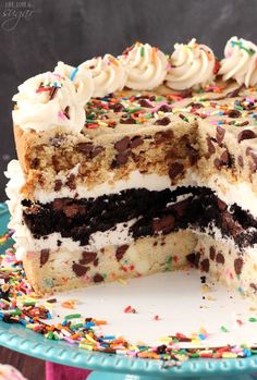 a cake with white frosting and sprinkles sitting on top of a blue plate