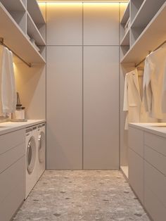 a washer and dryer in a room with white cabinets on the walls,