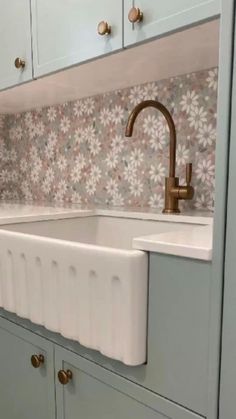 a white sink sitting under a faucet in a kitchen