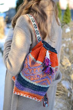 a woman carrying a multicolored bag in the snow