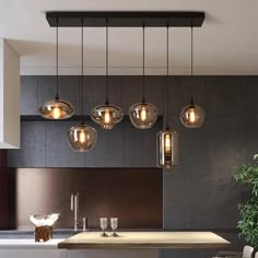 a kitchen with an island and lights hanging from the ceiling