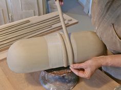 a person is making a vase out of clay on a potter's wheel,