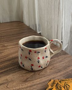 a cup of coffee sitting on top of a wooden table