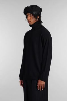 Knitwear in black wool, high collar, long sleeves, back print, ribbed cuffs and bottom, 100% wool, Made in Japan, Model is 1. 83 and wears size 3 Black Ribbed Cashmere Top, Black Cashmere Turtleneck For Fall, Wool High Neck Sweater With Ribbed Cuffs, Black Cashmere Long Sleeve Turtleneck, Black Long Sleeve Cashmere Turtleneck, Black Classic Funnel Neck Turtleneck, Black Cashmere Funnel Neck Top, Classic Black Turtleneck For Fall, Black Turtleneck Sweater For Work