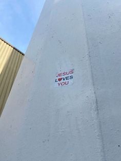 a sticker on the side of a building that says jesus loves you