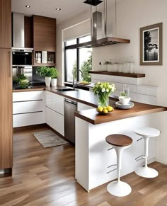 a modern kitchen with white cabinets and wood flooring is pictured in this image, there are two stools at the center of the island