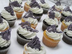 there are many cupcakes with white and purple frosting