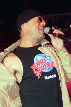 a man singing into a microphone on stage