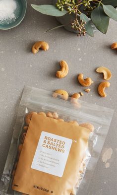 roasted cashews in a bag next to some leaves