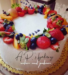 a cake decorated with fresh fruit and flowers