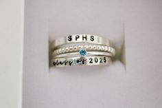 Class Ring, School Name Ring, Class of 2023, Class of 2024, Class of 2025, Class of 2026, Class of 2027, College Ring, High School Ring An alternative to traditional class rings, we're excited to offer a modern stackable version that is fun to wear! Please read all details below. Your set will include 4 rings: 1. School Name Ring   2. Birthstone Ring OR School Color 3. Beaded Spacer Ring 4. Class of  Ring S I Z I N G If unsure of size, please have a jeweler size your finger.  I am unable to resi Class Ring Alternative, Class Ring Ideas, Class Of 2027, Class Of 2026, High School Rings, College Ring, Class Rings High School, School Rings, College Rings