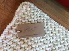 a white knitted blanket with a tag on it