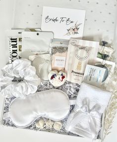 a white gift box filled with personal care items, including an eye mask and soap