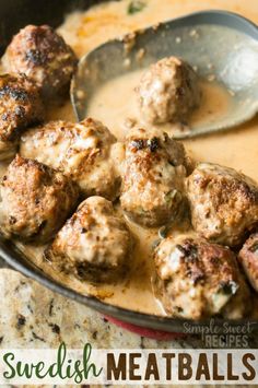 some meatballs are being cooked in a skillet with a spoon on the side