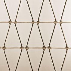 a close up view of a white tile wall with hexagonal shapes on it