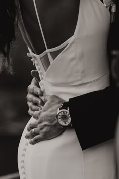 black and white photograph of woman in dress with hands on the back of man's chest