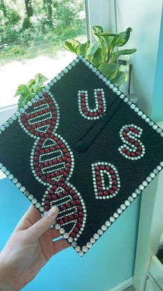 someone is holding up a graduation cap decorated with beads