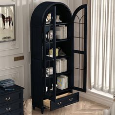 a black bookcase in a living room next to a window