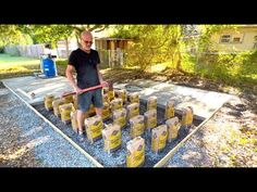 a man standing in front of a pile of yellow bags on top of a cement slab