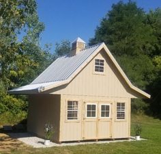 a small house with a metal roof and windows